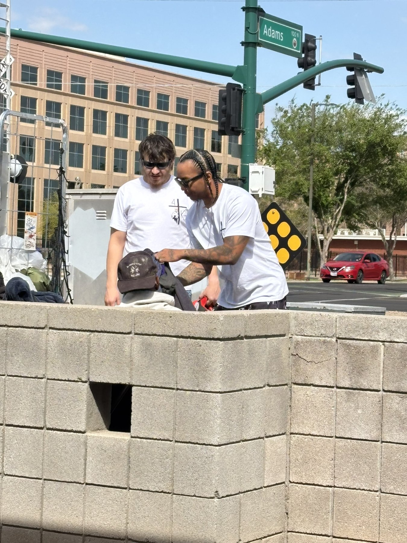 A 4TK volunteer handing folded clothing to a man on the street